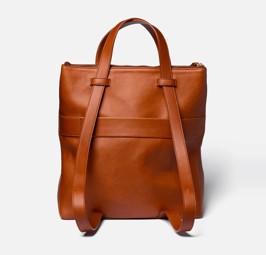 The tote worn as a backpack, seen from behind on white, its two straps let out